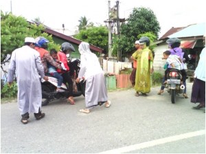 RAZIA CELANA KETAT. "Seorang perempuan pelaku razia berjubah putih –ditemani seorang pria yang juga berjubah putih– melakukan penyemprotan ke korbannya yang masih duduk di atas sepeda motornya. Di sini, lagi-lagi kaum perempuan menjadi korban utama."